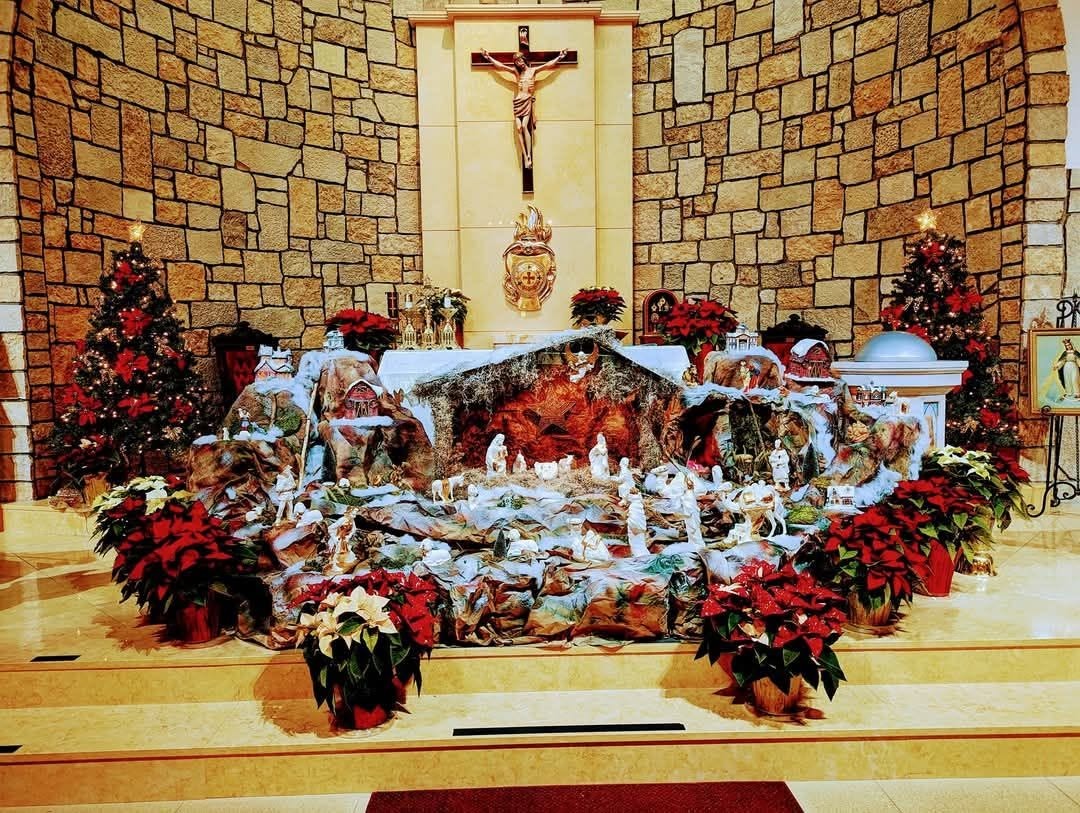 Interior of Our Lady of Lebanon showing the altar, crucifix, and stone sanctuary wall